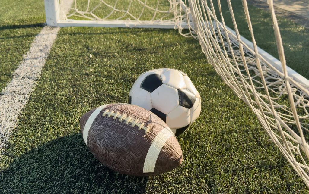 A football and soccer ball in a net