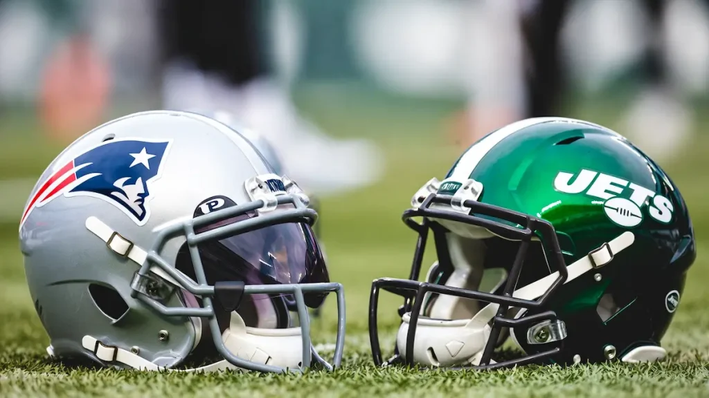 New England Patriot and NY Jets helmets set on the ground