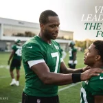 Candid header image focusing on quarterback Geno Smith mentoring younger players at the Jets practice facility, highlighting the veteran leadership and stability he provides for the 2026 season.